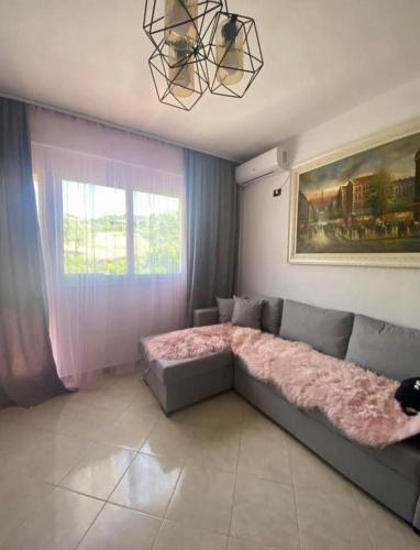 sala de estar con sofá y ventana en Holiday apartment, en Durrës