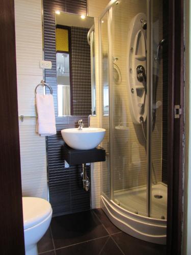 a bathroom with a sink and a shower and a toilet at Los Leones Hotel Boutique in Arequipa