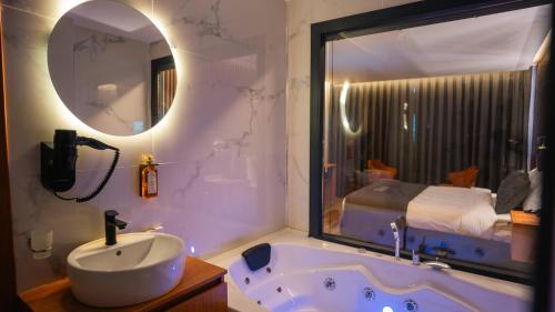 a bathroom with a tub and a sink and a mirror at Cip Hotel & Spa - İstanbul Bakırköy City Center in Istanbul