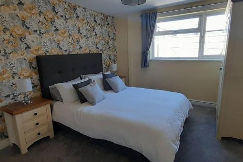 a bedroom with a large white bed and a window at Remarkable 2-Bed House in Walesby Nottinghamshire in Elkesley
