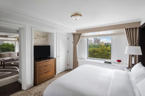 a hotel room with a bed and a television at The Ritz-Carlton New York, Central Park in New York