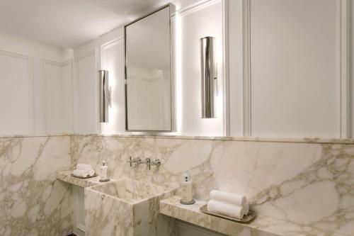 a white bathroom with a sink and a mirror at The Ritz-Carlton New York, Central Park in New York