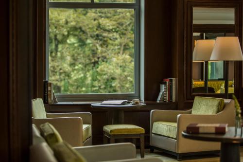 a room with a window and chairs and a table at The Ritz-Carlton New York, Central Park in New York