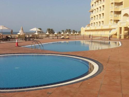 a large swimming pool in front of a hotel at Home away from Home in Ras al Khaimah