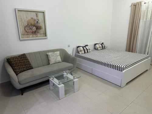 a living room with a bed and a couch at Home away from Home in Ras al Khaimah