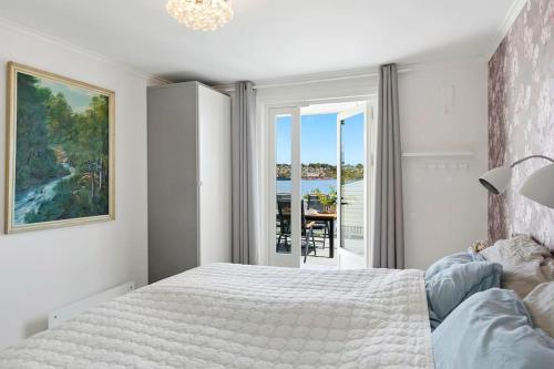 a bedroom with a bed and a view of the ocean at 3-bedroom terrace house with incredible sea views in Moss
