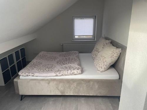 een bed in een kleine kamer met een raam bij Boarding Suite in Wendlingen am Neckar