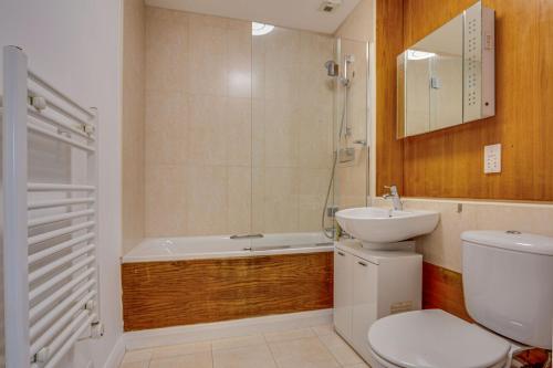a bathroom with a toilet and a sink and a bath tub at 2 Bed Apartment in West Hampstead in London