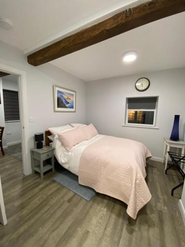 a bedroom with a bed and a clock on the wall at The Old Barn Overton 8 in Overton