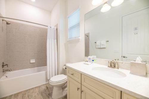 a bathroom with a sink and a toilet and a tub at Margaritaville Cottages Orlando with H2O Waterpark by Rentyl in Kissimmee