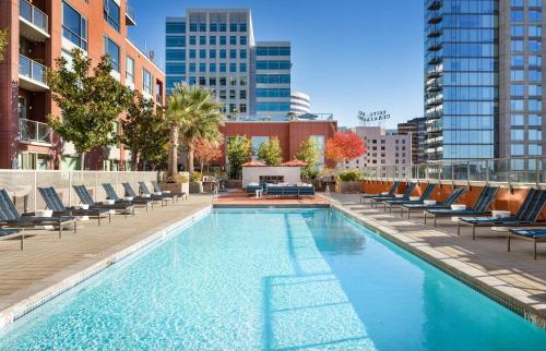 a swimming pool with lounge chairs on a building at Global Luxury Suites San Jose Downtown in San Jose