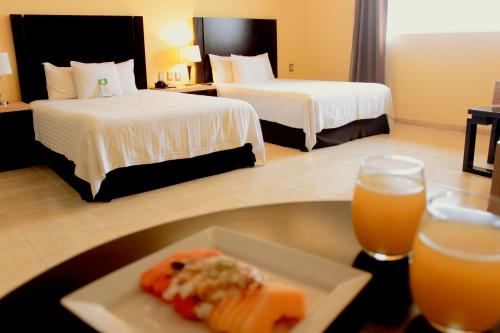 a hotel room with two beds and a plate of food at Hípico inn Hotel in Poza Rica de Hidalgo