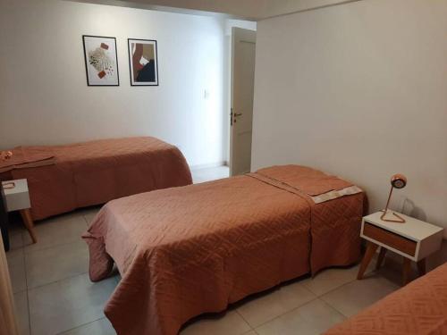 a room with two beds and a lamp on a table at La Fragua Suites Líbano in El Bolsón