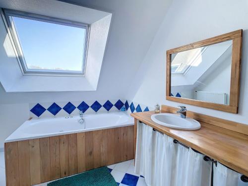 une salle de bain avec une baignoire, un lavabo et un miroir dans l'établissement Grande maison de vacances, à Agon-Coutainville