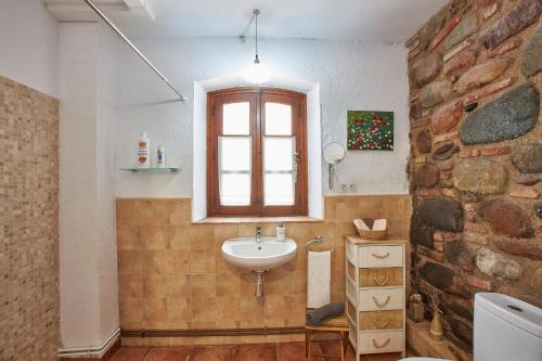 a bathroom with a sink and a brick wall at Mas Can Calet Aparthotel in Les Franqueses del Vallès