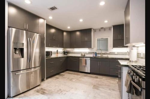 a kitchen with stainless steel appliances and brown cabinets at Private Room2 Own Entry Shared Bath One Guest Walk to UCSD in San Diego