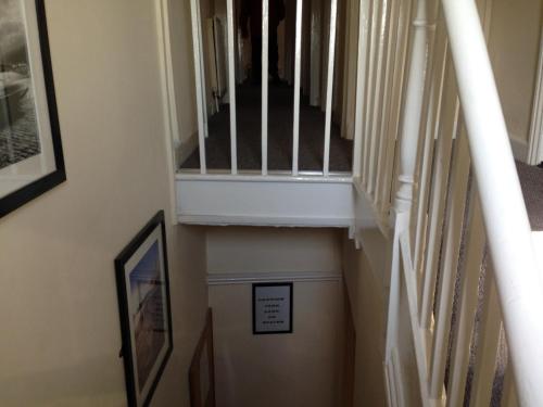 a hallway with a stairway with a sign on it at Acapulco Rooms in Portsmouth