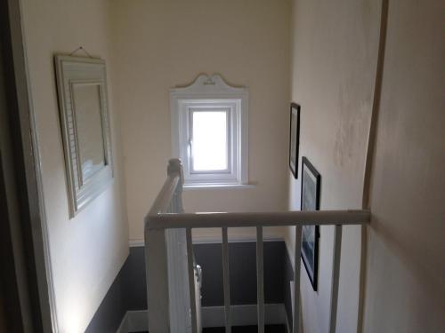 a stairway with a window and a stair case at Acapulco Rooms in Portsmouth