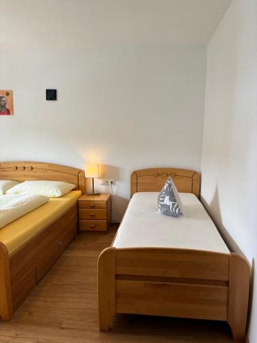 1 dormitorio con 2 camas individuales y mesita de noche en Gasthaus Kirchenwirt en Schwoich