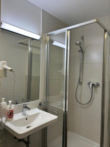 a bathroom with a sink and a shower at Gasthaus Kirchenwirt in Schwoich