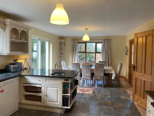 uma cozinha com uma mesa e uma sala de jantar em Letterfrack Farm Cottage in village on a farm beside Connemara National Park em Letterfrack