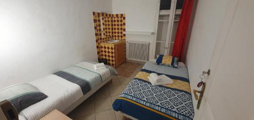 Duas camas num pequeno quarto com uma janela em LE COMPTOIR em Sainte-Croix-de-Verdon