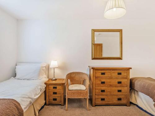 a bedroom with a bed and a dresser and a mirror at 4 Bed in The Cairngorms 46162 in Tomintoul