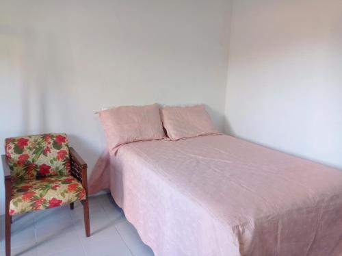 1 dormitorio pequeño con 1 cama y 1 silla en Kitnet Mobiliada en Camaçari