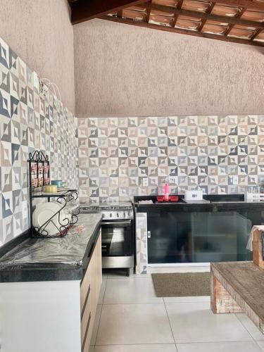 a kitchen with a stove and a counter top at Quarto com Área gourmet e piscina privativo in São João da Barra