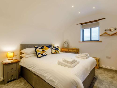 um quarto com uma grande cama branca e uma janela em 2 Bed in Umberleigh 54354 em Atherington