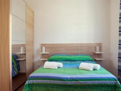 1 dormitorio con 1 cama verde y 2 toallas en I Tramonti Sul Mare, en Marsala
