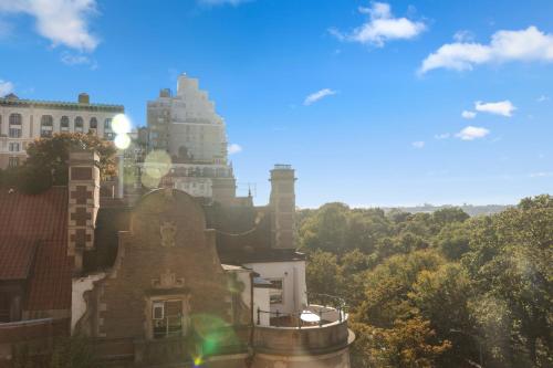 an old building on a hill with trees in the background at Riverside Tower Hotel in New York