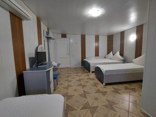 エフォリエ・スドにあるCasa Simonaのベッド2台とテレビが備わるホテルルームです。
