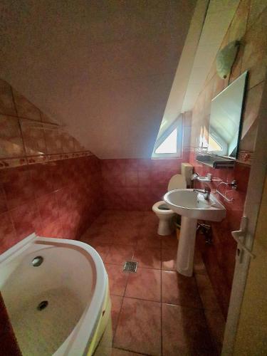 a bathroom with a tub and a sink and a toilet at Casa Simona in Eforie Sud