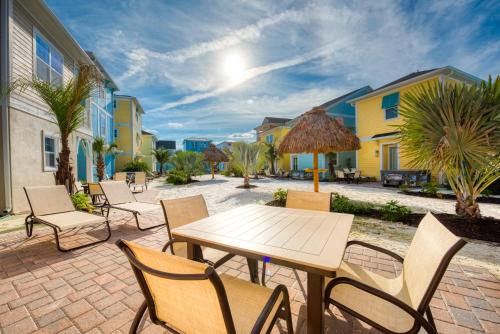 a patio with tables and chairs and palm trees at Margaritaville Cottages Orlando with H2O Waterpark by Rentyl in Kissimmee