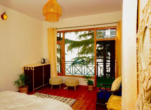 a bedroom with a bed and a large window at Unwind Stays in Nagar