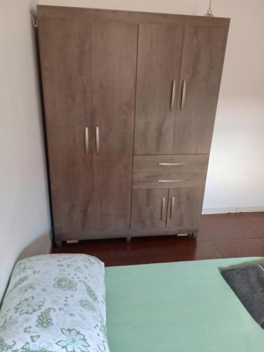 a bedroom with a wooden cabinet and a bed at Tedesco in Palmas