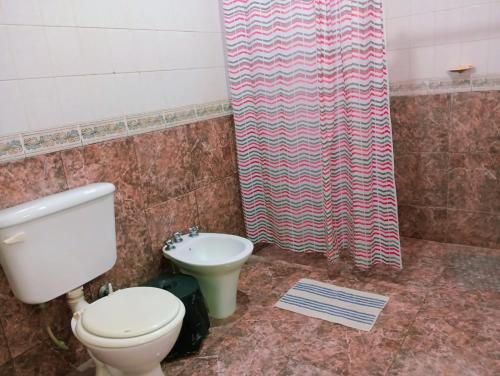 a bathroom with a toilet and a shower curtain at M y M Departamento in Belén