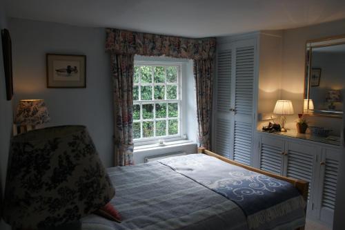 a bedroom with a bed and a window at IVY COTTAGE in Pulborough
