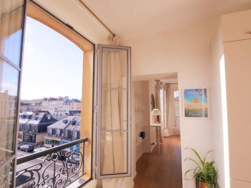 a room with a balcony with a large glass door at Charme et modernité au coeur du quartier St Louis in Versailles
