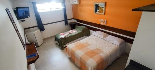 Habitación pequeña con cama y ventana en Hotel Casa Branca, en Guarujá
