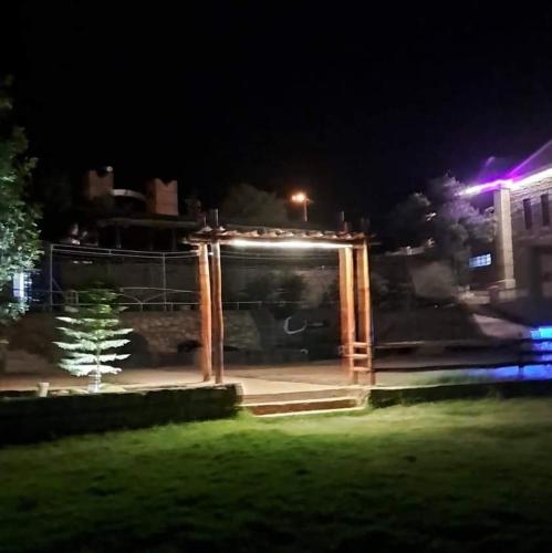 um gazebo iluminado num parque à noite em Chalet kaddoum em Beni Mellal
