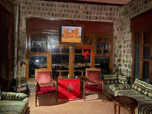 uma sala de estar com sofás e cadeiras e uma janela em Chalet kaddoum em Beni Mellal