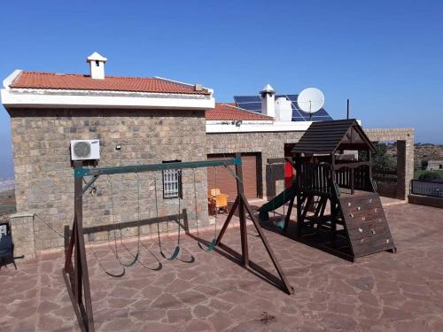 um parque infantil com um baloiço no telhado em Chalet kaddoum em Beni Mellal