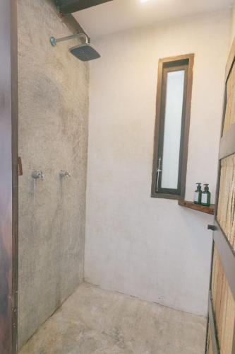 a bathroom with a shower and a window at Nahouse Jungle Lodges in Tulum