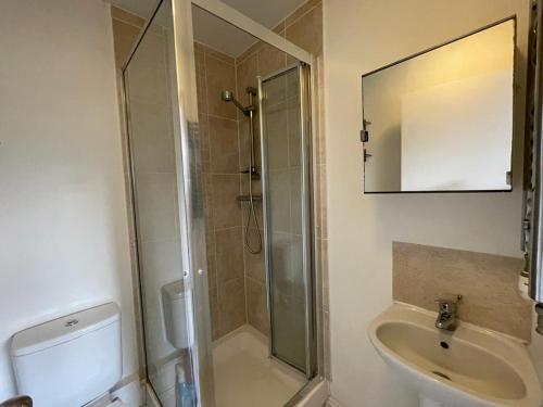 y baño con ducha y lavamanos. en Double bedroom with bathroom en suite in London Docklands Canary Wharf E14, en Londres