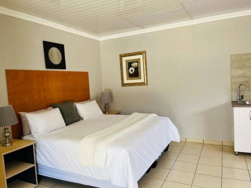 een slaapkamer met een groot wit bed in een kamer bij Private room in Rustenburg in Rustenburg