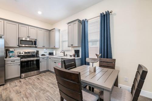 a kitchen and dining room with a wooden table and chairs at Margaritaville Cottages Orlando with H2O Waterpark by Rentyl in Kissimmee