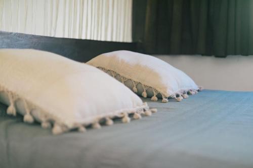 three pillows sitting on top of a bed at Nahouse Jungle Lodges in Tulum