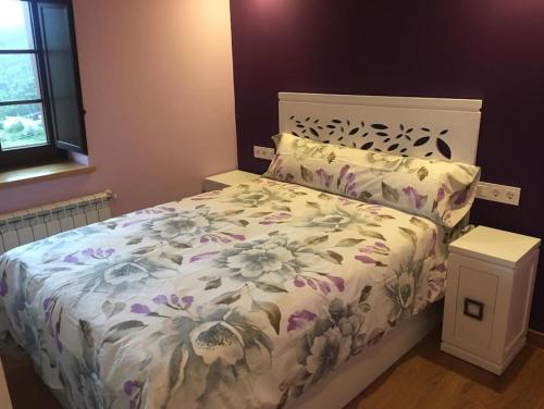 een slaapkamer met een bed met een bloemdekbed bij La Casa del Marinero in Cudillero